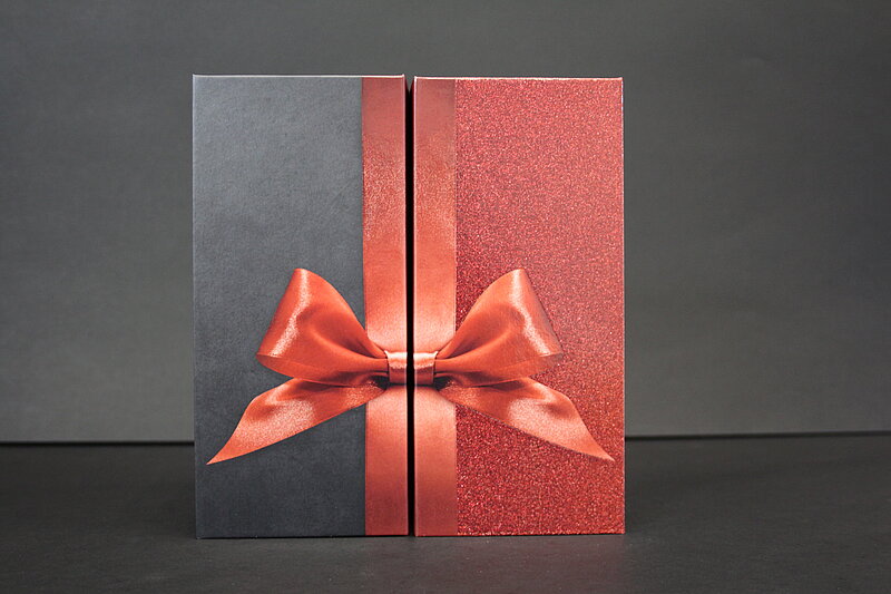 geschlossene schwarze twin box packaging design mit roter schleife von achilles verpackungen